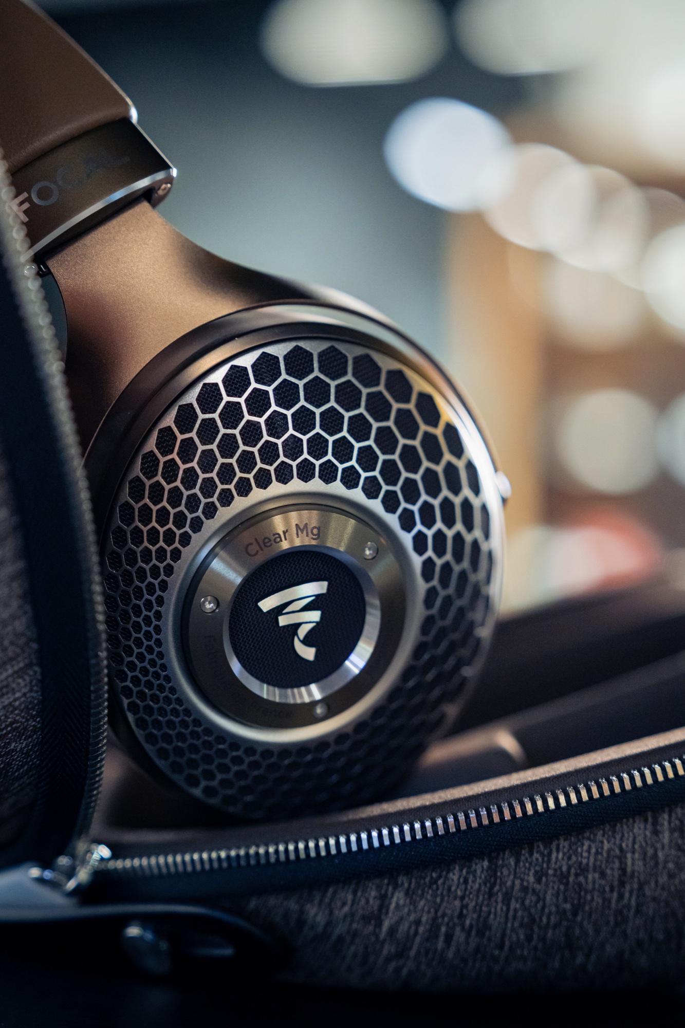 Focal Clear Mg earcup in its case, with its metallic grille and logo in focus